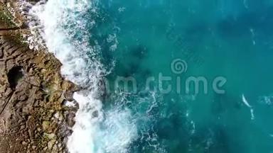 奇妙的土耳其蓝色海水撞击岩石-从上往下看