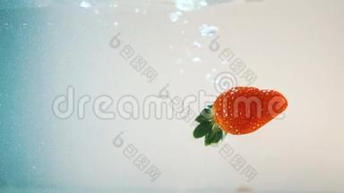 红熟多汁的草莓缓慢地<strong>落入</strong>水中