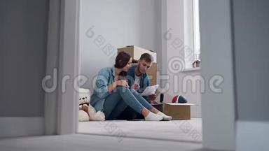 <strong>喜笑颜开</strong>的一对恋爱中的情侣坐在新公寓的地板上，讨论`的设计