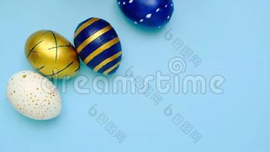 复活节彩蛋<strong>滚滚</strong>，互相敲着蓝桌子.. 鸡蛋时髦的彩色经典蓝色，<strong>白色</strong>和金色。 快乐