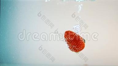红熟多汁的草莓缓慢地落入水中