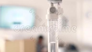 医院模糊豪华贵宾室背景下患者和输液泵盐水滴液的特写。