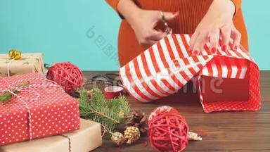 女人`手把圣诞假日手工礼物<strong>绑</strong>在手工纸上，用缠绕<strong>丝带</strong>。