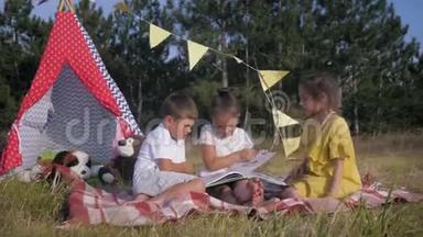 小朋友在大自然中读书，可爱的孩子在户外玩耍的同时，一起读儿童读物
