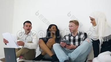 四个自信勤劳的混合种族办公室工人坐在地板上讨论他们的联合项目
