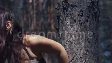 靠近一个穿着毛皮和皮衣的年轻亚马逊人，<strong>坐在树下</strong>