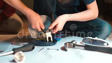 一个青少年正在修理一个光盘播放器。