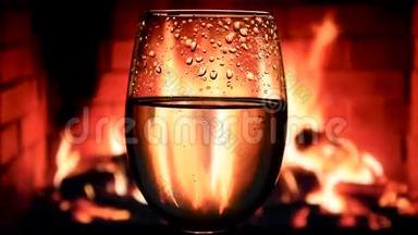 壁炉背景的高脚杯中的白葡萄酒，葡萄酒商业的美丽库存镜头