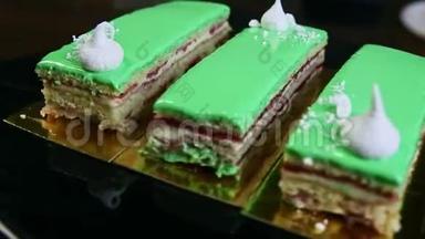 特写黑色托盘与三个绿色釉层蛋糕部分旋转周围