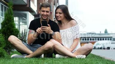 快乐的一对夫妻在草地上玩手机，上<strong>网购</strong>物，冲浪