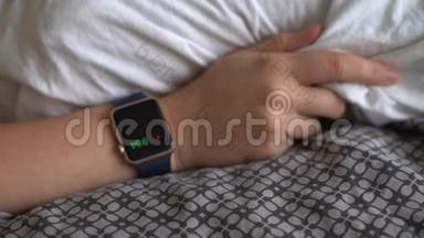 把智能手表放在床上。 监测睡眠模式和脉搏。