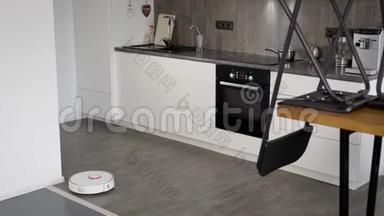 机器人吸尘器正在厨房的瓷砖地板上移动，室内采用现代简约风格