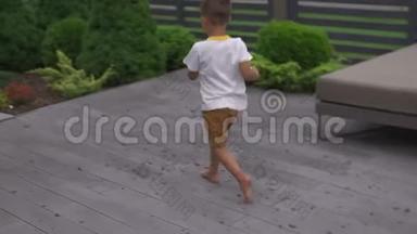 小男孩儿子穿着t恤和短裤在花园里玩捉迷藏-家庭<strong>价值观</strong>温暖的夏季场景