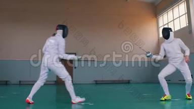 两个穿着白色服装的年轻女子在学校体育馆进行击剑训练