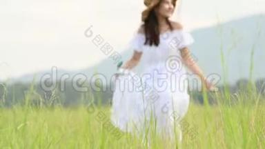 穿着白色衣服的亚洲女人正漫步在<strong>辽阔</strong>的草原上，用手触摸绿草的顶端。 在草地上散步的女孩