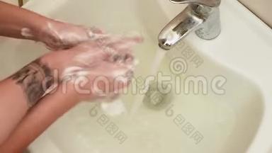 把两双手放在水槽上。 女孩们用肥皂洗手，开始争夺肥皂和海绵。