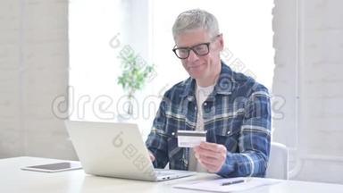 成功的休闲中年男子在线支付笔记本电脑