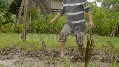 一个土著小男孩正在泥泞的<strong>足球场上踢球</strong>