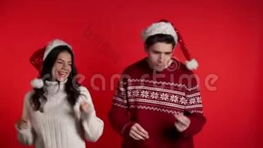 年轻夫妇在圣诞装<strong>饰品</strong>上跳舞，圣诞老人<strong>戴</strong>着红帽子