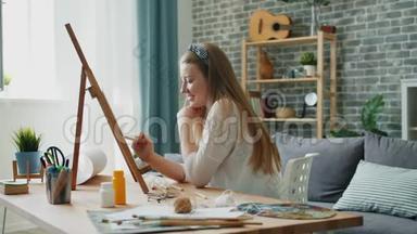 一位年轻的女设计师在家中画画画架，坐在公寓里