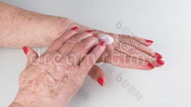 快乐的老年妇女使用手霜，保持皮肤健康