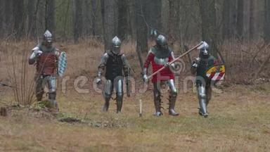 四个人穿着全副武装在森林中的一排骑士