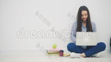 年轻的亚洲女学生坐在洛托斯的位置上，用手提电脑，用手指举起来，<strong>就好</strong>像在拿着一个