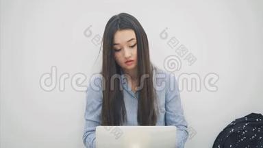 可爱的亚洲小姐坐着，拿着<strong>笔记本</strong>电脑，举起一张纸，<strong>上面</strong>写着问号，点点头