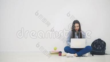 一位亚洲女士坐在地<strong>板</strong>上，拿着笔记本电脑，<strong>举</strong>起双<strong>手</strong>，挥舞着双<strong>手</strong>，开心地笑着