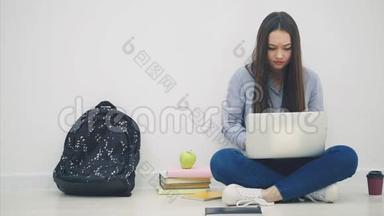 可爱的亚洲年轻女士坐着，带着笔记本电脑，有一些困难，紧握着拳头，双手握着