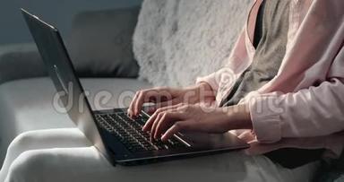 靠近坐在沙发上拿着笔记本电脑的年轻女人