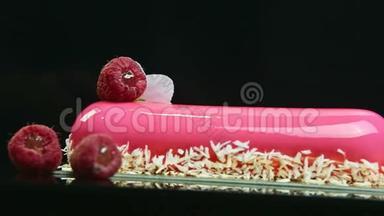 在粉红色釉面长椭<strong>圆形蛋糕</strong>与椰子刨花和覆盆子的特写全景