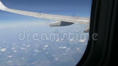 飞机飞过罕见的蓬松云。 从飞机机翼上的舷窗可以看到欧洲的田野