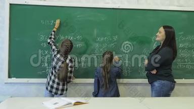 <strong>小</strong>学。 <strong>小女生</strong>在教室的绿色粉笔板上写数字
