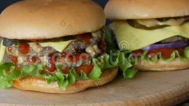 两份美味的大汉堡芝士汉堡或汉堡，里面有一片多汁的生菜叶、一片番茄、奶酪和一块肉