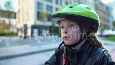 坐在自行车上戴着运动头盔的专心致志的小女孩，准备骑户外运动