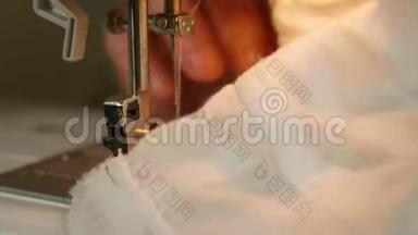 把女人的手举`白色的材料，缝在缝纫机上。