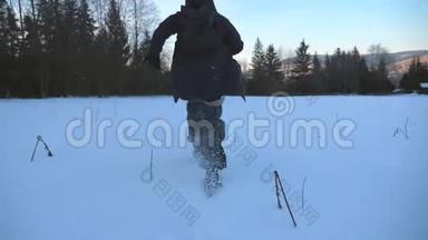 在森林边缘的雪地草坪上慢跑的不可辨认的家伙的后景。 年轻人在雪地上奔跑