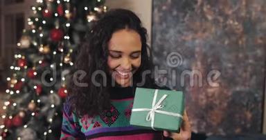 快乐迷人的微笑穆拉特女孩，手里拿着漂亮的包裹圣诞礼物，<strong>纠正</strong>弓，站在附近