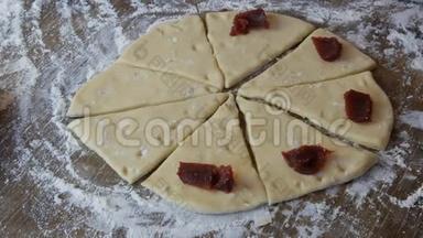 新鲜面团上的红樱桃果酱，自制蛋糕，厨房里的一个女面包师做面团面包