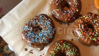 新鲜可口的圆形甜甜圈，有多种颜色的巧克力糖衣，粉色、蓝色、白色、橙色、绿色和各种装饰
