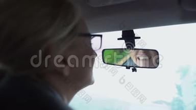 女人在汽车、牙龈和<strong>牙齿</strong>敏感的后视镜里看着她的<strong>牙齿</strong>