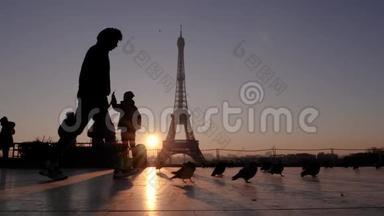 埃菲尔铁塔背景上的人和鸽子的剪影。一个人走过摄像机。慢动作