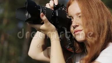 带照相机的红发女孩满脸雀斑，正微笑着看着夕阳。