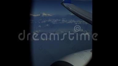 从飞机窗户上看到的山、云、飞机发动机、机翼。 喜马拉雅山。 珠峰