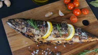 美味的新鲜鱼，烟熏鲭鱼放在樱桃番茄旁边的木砧板上，大蒜，粗盐和