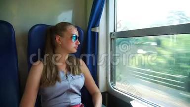 戴墨镜的女孩在火车上<strong>看着窗外</strong>笑