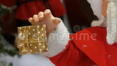玩具手拿礼盒.. 在商场的圣诞展览上搬圣诞老人玩偶。 圣诞假日装饰