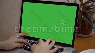 带有绿色屏幕的笔记本电脑。 女人在电脑上打钥匙绿色模拟笔记本