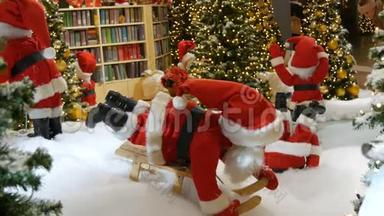 在商场的圣诞展览里搬圣诞老人玩偶。 圣诞假日装饰